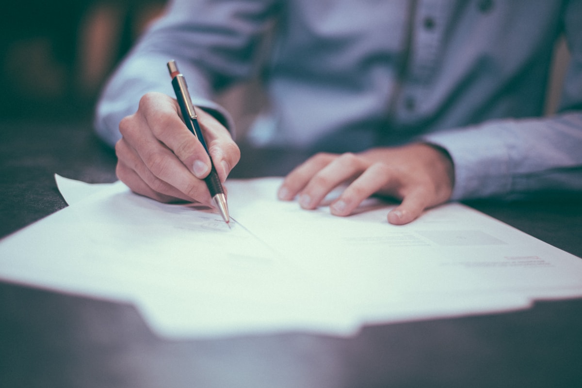 Person reviewing and signing an important planning document